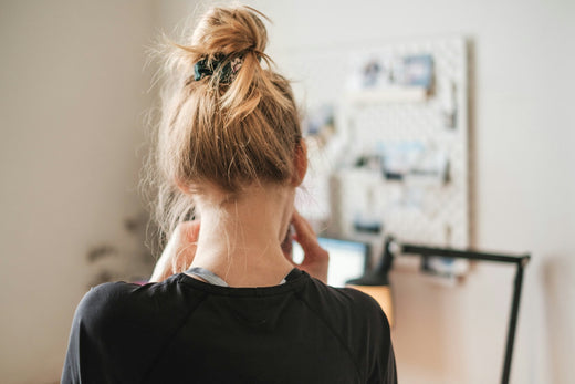 A stressed women with her back to the camera in a home offcie